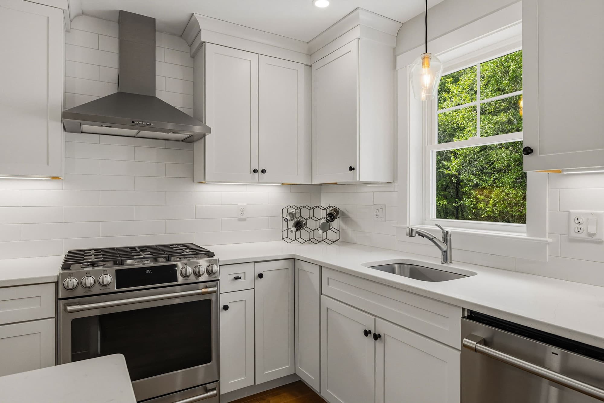 Kitchen with a gas range, vent hood, and quartz counters