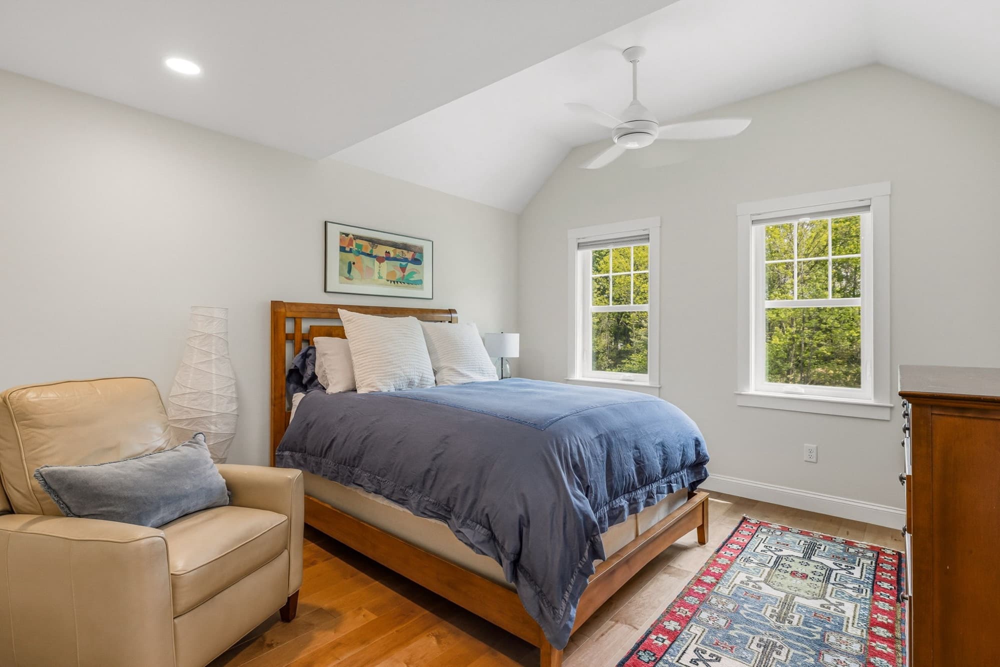 Vaulted primary bedroom with a ceiling fan