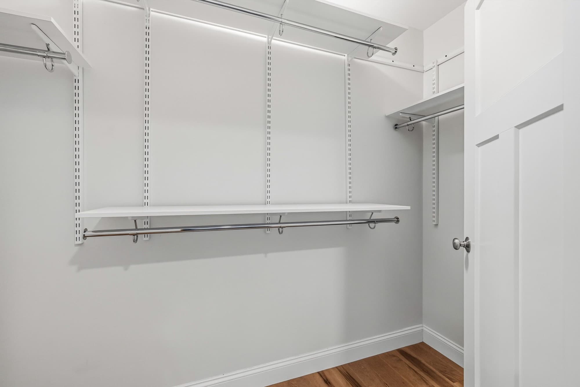 Primary walk-in closet with built-in shelving