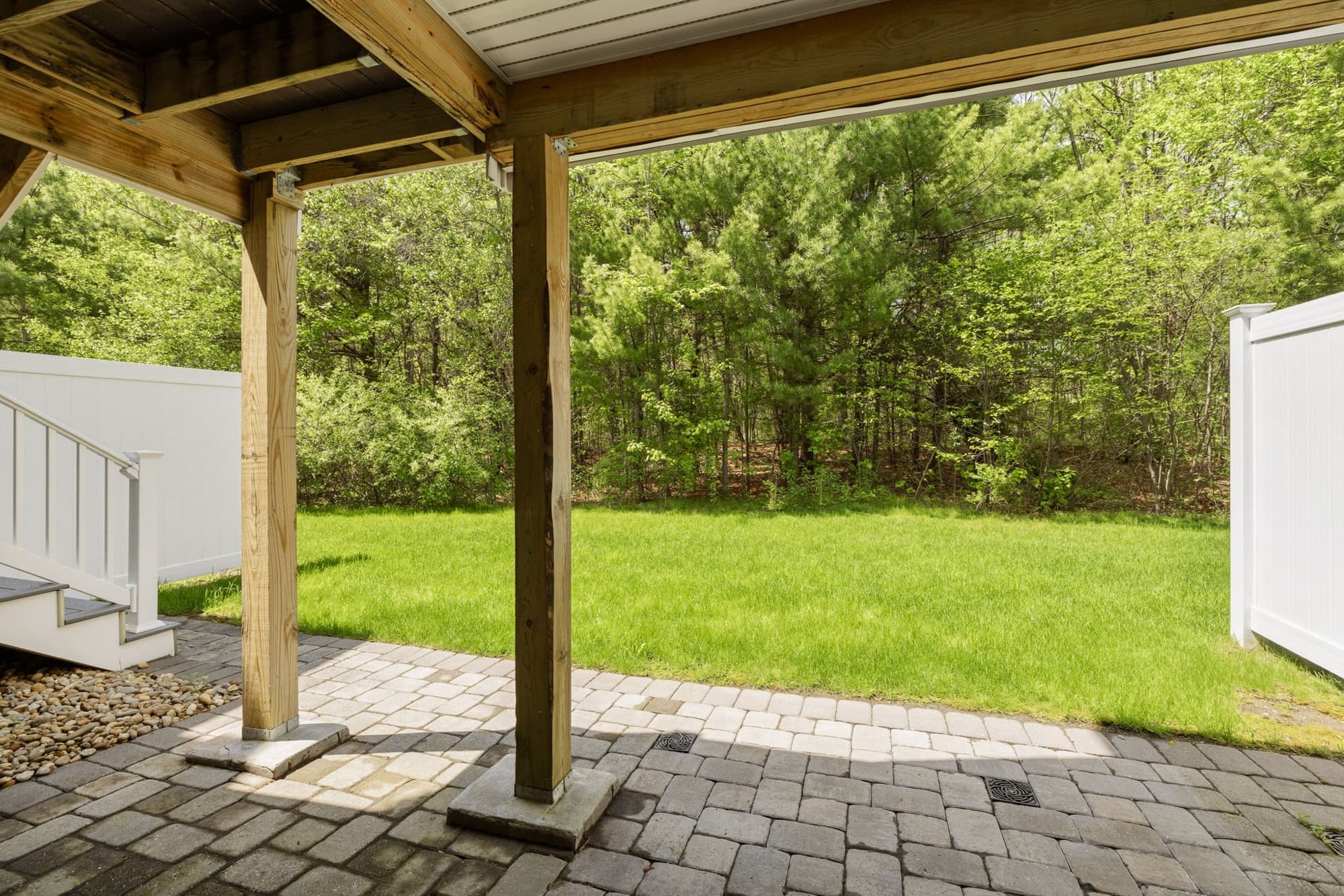 Covered patio beneath the deck with the backyard beyond