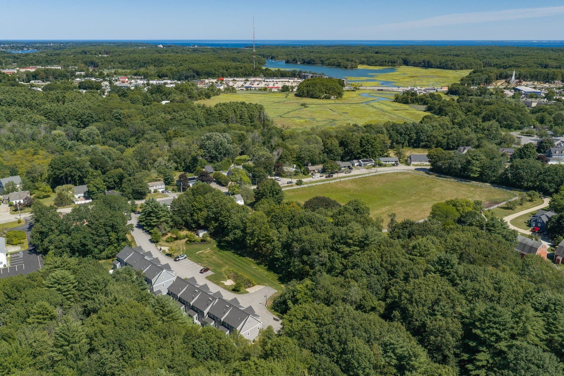 Aerial view over the neighborhood with tidal marsh and water in the distance
